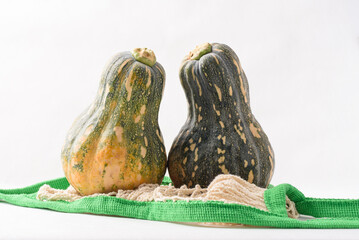 Ripe, yellow-green butternut squash after autumn harvest from an organic farm, on a white background. A healthy cooking ingredient