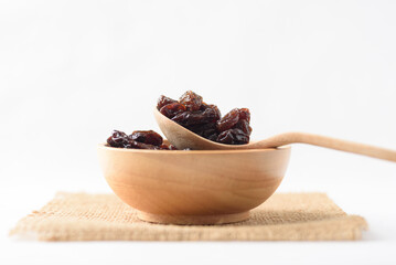 Dried dark raisins on a white background. A healthy snack