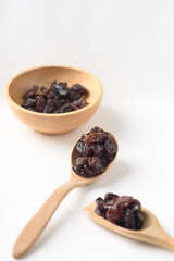 Dried dark raisins on a white background. A healthy snack