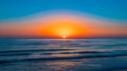 Obraz premium Breathtaking Symmetrical Ocean Sunrise or Sunset with Vibrant Blue and Orange Sky