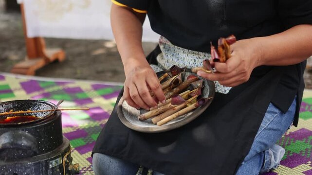 Woman preparing canting tools for making Indonesian batik