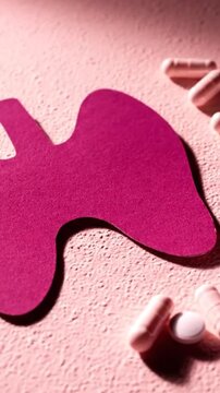 Thyroid Gland Paper Cutout with Capsules on Pink Backdrop Displaying Endocrine System Awareness and Medication in Vertical Close Up Perfect for Medical or Pharmaceutical Use