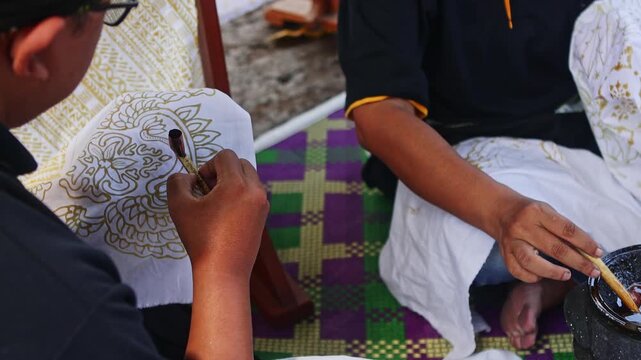 Traditional Indonesian batik making process with canting