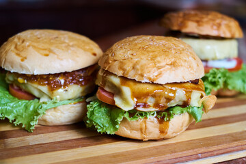 Assortment of Gourmet Cheeseburgers on Wooden Board – Fresh Homemade Fast Food Concept