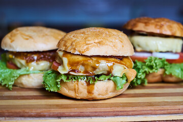 Assortment of Gourmet Cheeseburgers on Wooden Board – Fresh Homemade Fast Food Concept