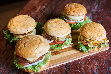 Assortment of Gourmet Cheeseburgers on Wooden Board – Fresh Homemade Fast Food Concept