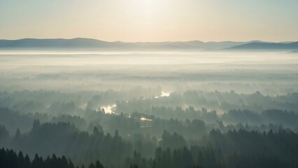 Naklejka premium Misty Morning Landscape with Foggy Valley and Distant Mountains at Sunrise.