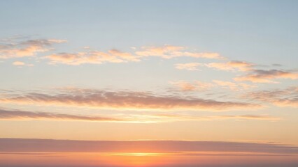 Calm pastel sunset sky with thin stratified cloud layers, illustrating stable atmospheric conditions and natural light gradients in weather phenomena.