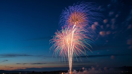 Vibrant colorful fireworks explode against the deep twilight sky celebrating a festive holiday occasion outdoors
