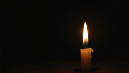 Lit candle in darkness for Holocaust Remembrance Day