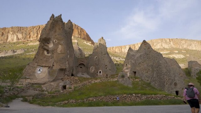 Woman walking towards ancient Soganli Valley cave church in Cappadocia, Turkey