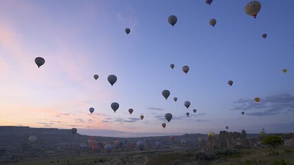 Colorful hot air balloons creating a beautiful spectacle over the unique landscape of Cappadocia, Turkey