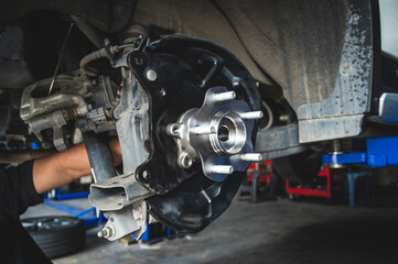 Auto mechanic installing a new wheel hub bearing , wheel hub bearing replacement in garage service...