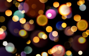 Colorful blurred Bokeh lights on black background used for overlay. Rainbow pastel Bokeh lights multicolour. Abstract glowing dynamic sparks or Bokeh lights background.
