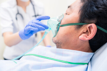 人工呼吸器をつけた患者のケアをする看護師の女性