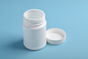 Opened blank plastic bottle medicine isolated on blue background.