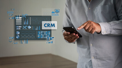 Businessman using smartphone with mobile CRM dashboard overlay showing charts, graphs, database metrics and business intelligence analytics crm