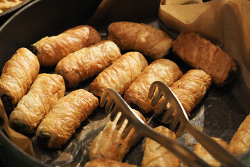 Freshly baked pastry rolls on a tray in a kitchen