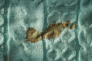 Brown stain on light blue knitted fabric