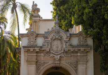 View of the medallion and elaborate embellishments adorning the top of the arch in one of the  historic buildings in Balboa Park in San Diego, Ca.