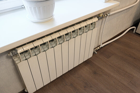 White radiator, metal pipes, wooden flooring, minimalist interior, heating, climate control