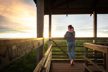 Woman Enjoying Sunset View from Wooden Observation Tower