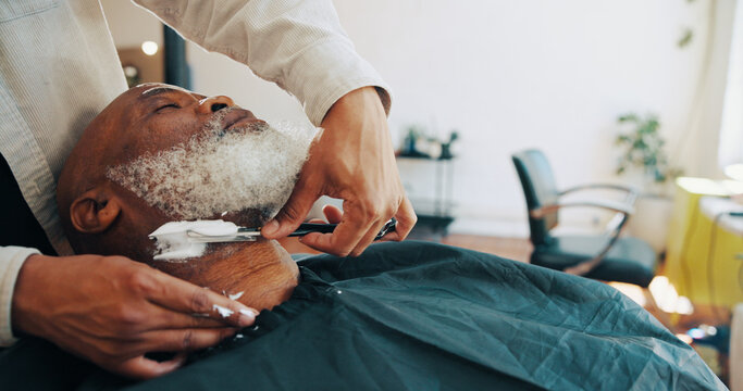 Shave, barber and man with customer in chair for grooming, haircut and trim for beard service. Hair salon, appointment and people with razor for styling, wellness and hairdresser in barbershop - Powered by Adobe