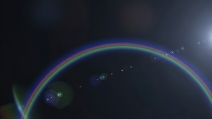 Rainbow colored circular light flare with sparkling effects on black background