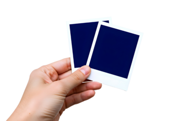 Hand holding two blank polaroid photos against white background isolated on transparent background