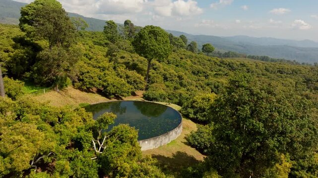 DRONE: (NOON) DOLLY IN SHOT OF A WATER STACK AT A BIG AVOCADO FARM IN URUAPAN, MICHOAC&Aacute;N.