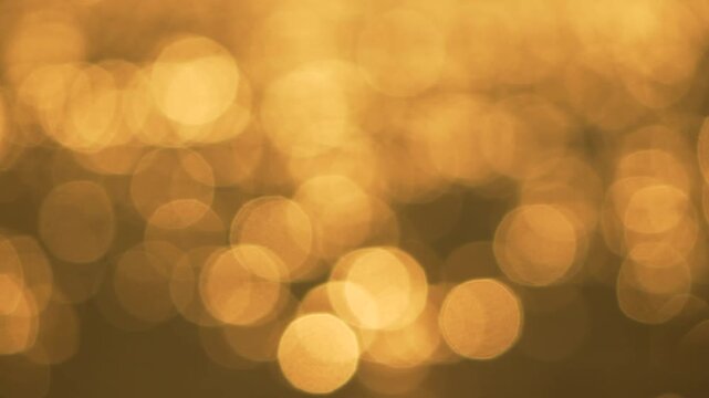Bokeh shimmering gold, abstract background of sparkling warm light on water surface