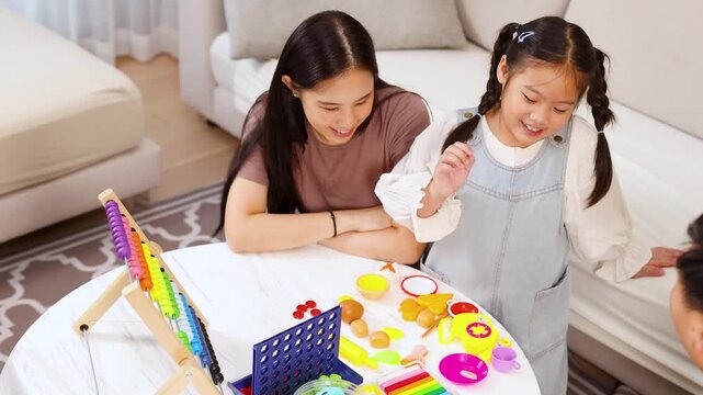 Asian Family Playing Educational Board Game Together at Home
