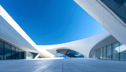 Striking modern architecture with smooth, curving white walls and geometric forms framing a clear blue sky, emphasizing clean lines, space, and contemporary design.