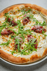 Try our white pizza with creamy toppings, tasty meat, and fresh greens—perfect for sharing!
