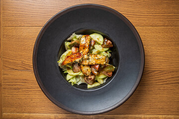 Grilled chicken on crunchy lettuce and vibrant tomatoes in a sleek bowl