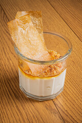 Creamy dessert layered with caramel and crispy texture rests elegantly on a rustic wooden surface
