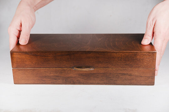wooden box on white cardboard vintage background closed in woman hands