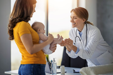 Fototapeta premium Pediatric check-up is friendly and warm as doctor greets mother and baby in a bright clinic