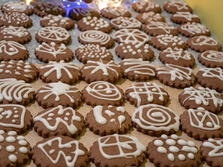Small baked Christmas cookies, homemade gingerbread cookies decorated with icing, close-up