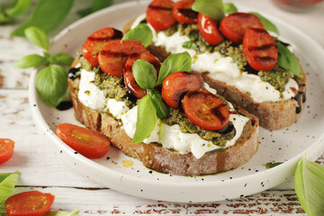 Italian sandwiches with grilled tomatoes, burrata cheese and pesto