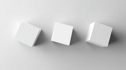 Three identical white cubes arranged in a row on a light gray surface,
