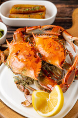 Whole cooked crab plated with lemon and side condiments