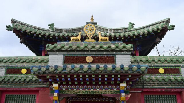 Ornate pavilion roof at Erdene Zuu Monastery. Features a golden Dharma Wheel and deer on intricate green eaves, highlighting Mongolia's religious heritage.