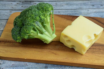broccoli and Emmental cheese on wooden board