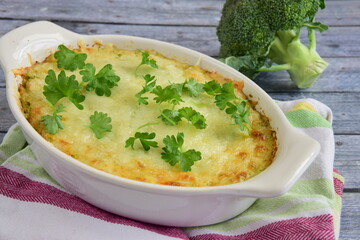 Baked broccoli with cheese on baking dish garnish with parsley