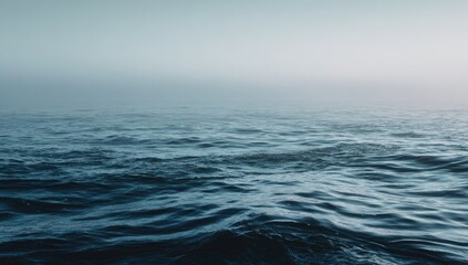 Serene seascape showing ocean water surface shrouded in mist, transitioning to a clear sky