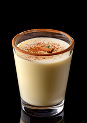 Festive Christmas eggnog in a bottle isolated on a black background, traditional Christmas drink