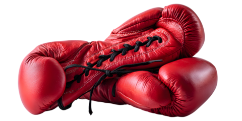 A pair of vibrant red leather boxing gloves with black laces lying on a dark background isolated on white background
