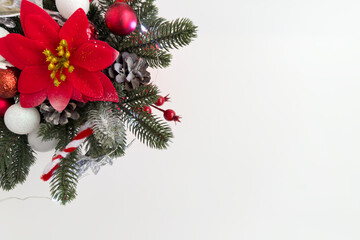 Vibrant red flower arrangement with pine branches, ornaments, and decorative elements, creating a festive atmosphere for holiday celebrations and seasonal decor with copy space