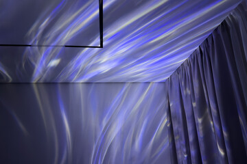 Abstract interior scene featuring soft blue and white light of projector on textured walls and ceiling, creating a serene atmosphere with flowing patterns and gentle ambiance